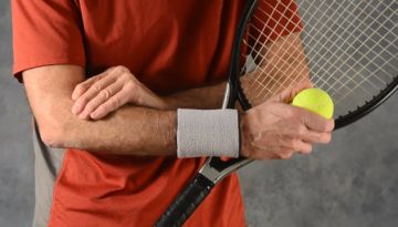 tennis player massaging elbow