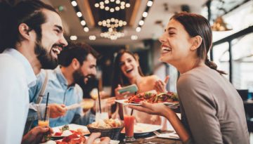 Group of Happy friends having breakfast in the restaurant